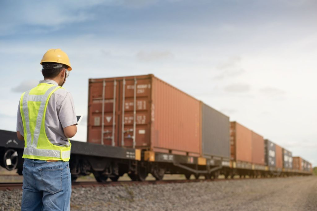 A man in a hard hat standing next to a train